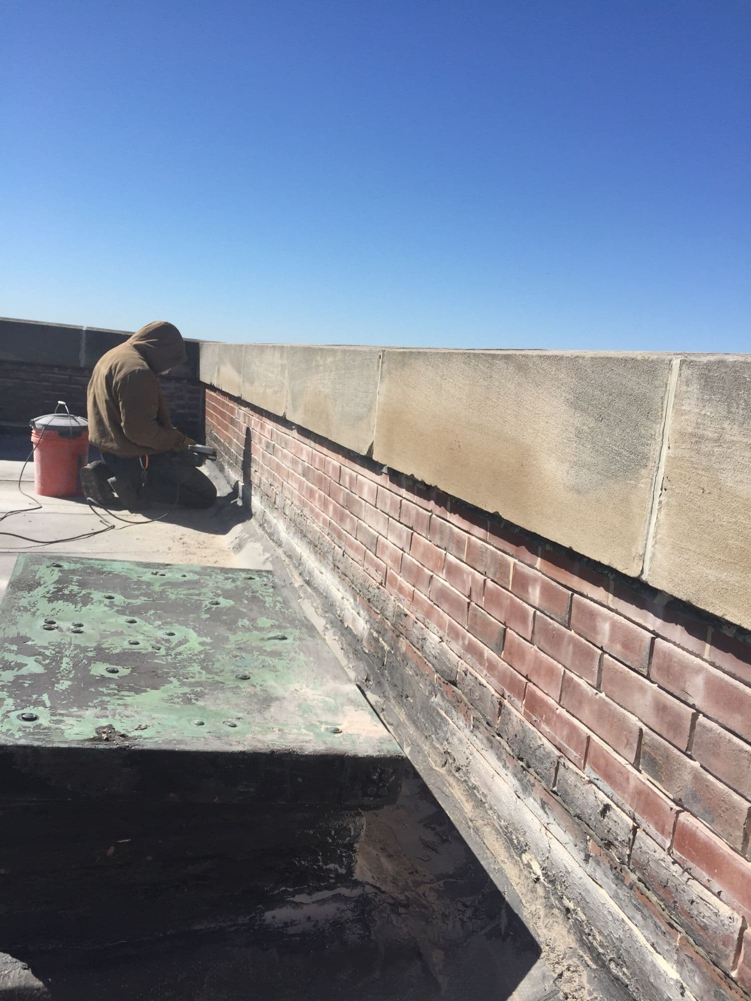 IToch Roofing worker tuckpointing commercial brick parapet wall North Shore Chicago